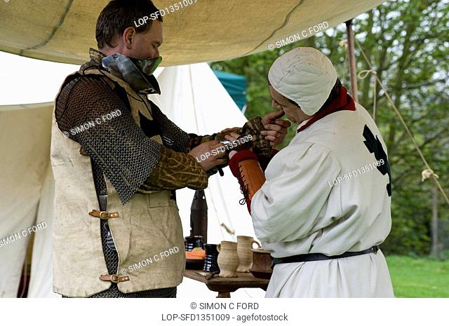 England, Essex, Castle Hedingham, A knight being prepared for battle at a medieval re-enactment at Hedingham Castle