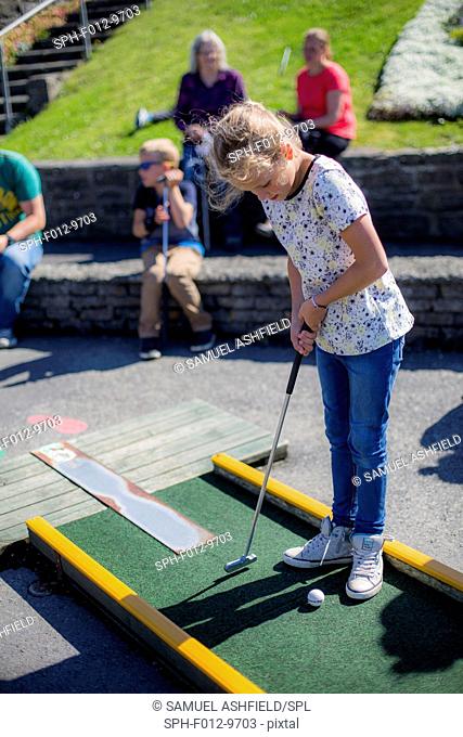 Girl playing mini golf