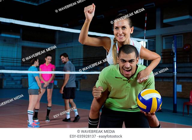 Portrait of volleyball player giving piggyback to teammate