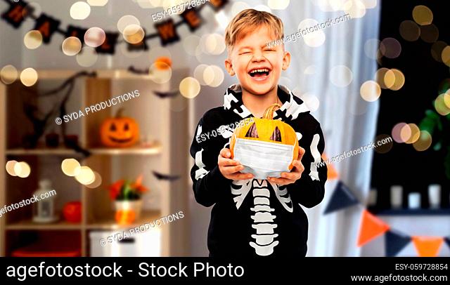 happy boy with pumpkin in mask on halloween