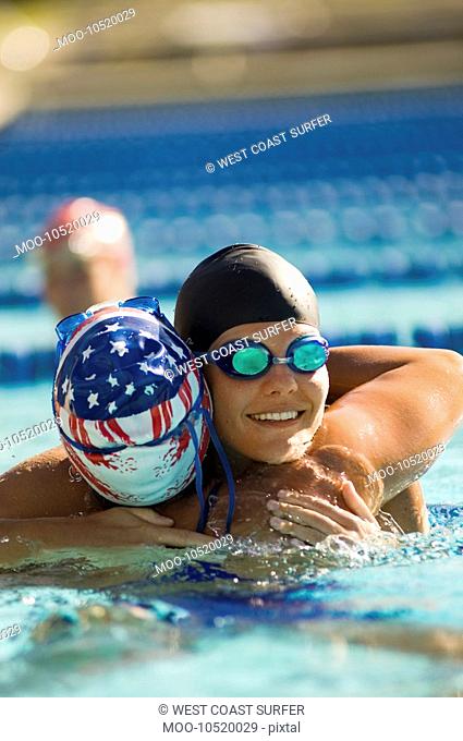 Female swimmer congratulating winner after race in pool