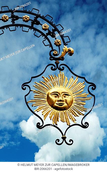 Hanging sign of Hotel Gasthof Sonne, restaurant and hotel, against a cloudy sky, Hauptstrasse, Gengenbach, Baden-Wuerttemberg, Germany, Europe