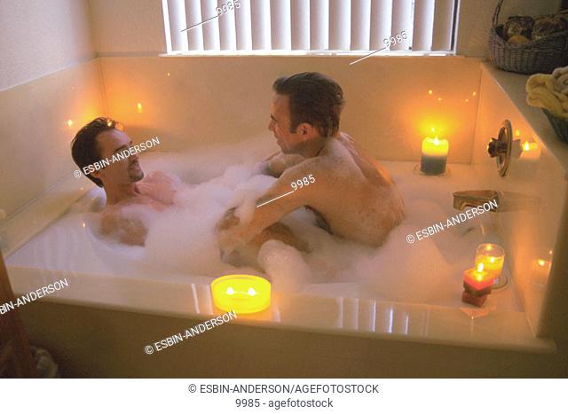 Gay men enjoy bubble bath together
