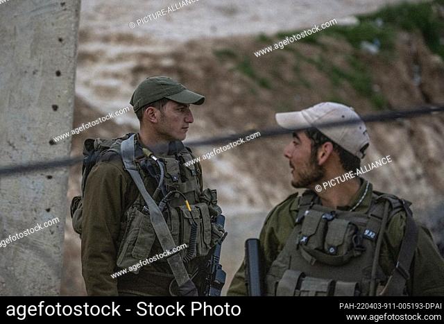 03 April 2022, Palestinian Territories, Hebron: Armed Israeli soldiers stand guard at their post after they were deployed to prevent Palestinian workers from...