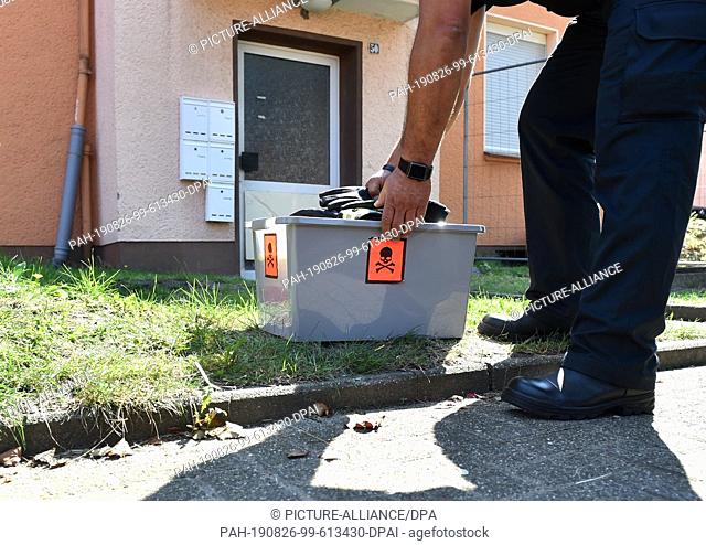 26 August 2019, North Rhine-Westphalia, Herne: Snake expert Roland Byner places a box in front of the front door of an apartment building