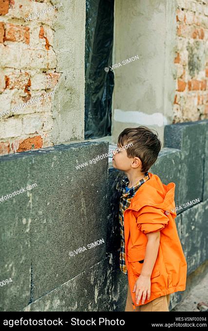 Boy looking at installed polystyrene on wall