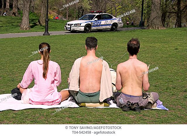Central Park. People meditating under watch of a NYPD vehicle. New York City. USA