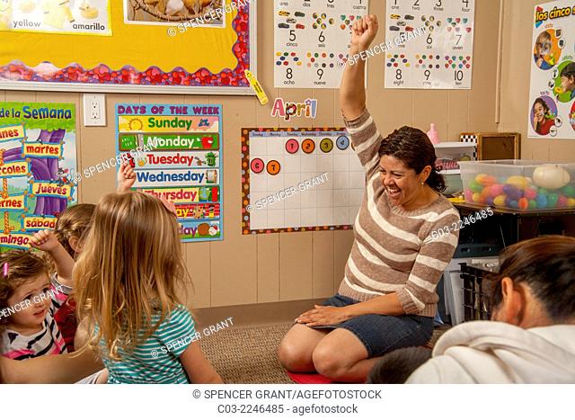 Explaining the calendar with enthusiasm, a Hispanic teacher works with young children and their parents at a ""Learning Link"" classroom in Tustin, CA
