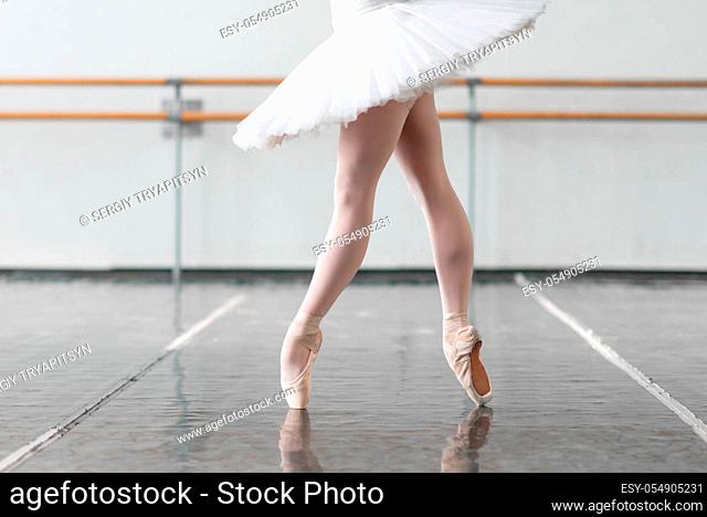 Female ballet dancer legs in pointe shoes. Ballerina keep the rack on rehearsal in class