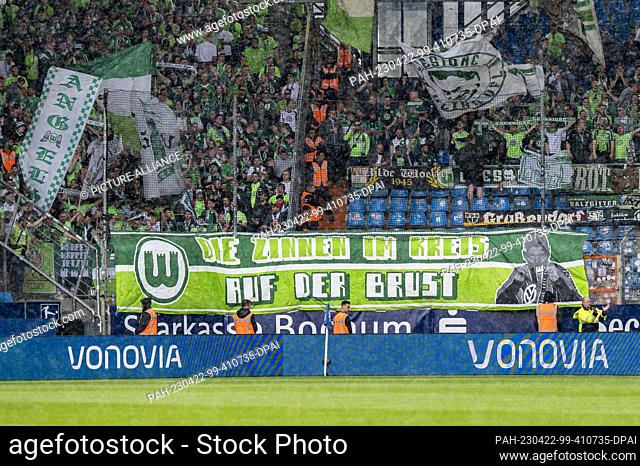 22 April 2023, North Rhine-Westphalia, Bochum: Soccer: Bundesliga, VfL Bochum - VfL Wolfsburg, Matchday 29, Vonovia Ruhrstadion: Wolfsburg fans display a banner...