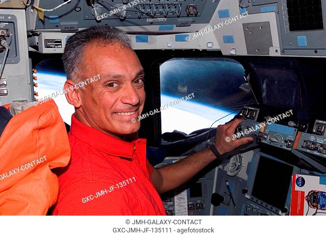 Astronaut John Danny Olivas, STS-117 mission specialist, occupies the commander's station on the flight deck of Space Shuttle Atlantis during flight day 12...