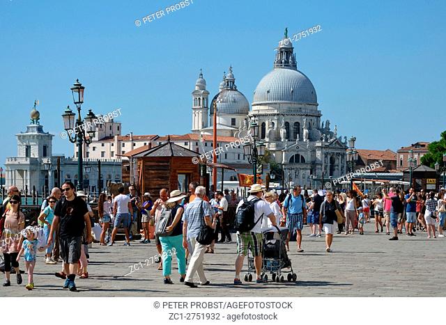 Venice, Veneto, Italy - September 6, 2016: View from the waterfront Riva degli Schiavoni with tourists at the Basilica Santa Maria della Salute of Venice in...