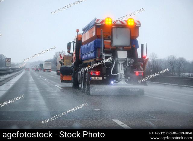 12 December 2022, Saxony, Schkeuditz: A gritting vehicle of the winter road clearance service drives on highway 9 and spreads salt on the roadway