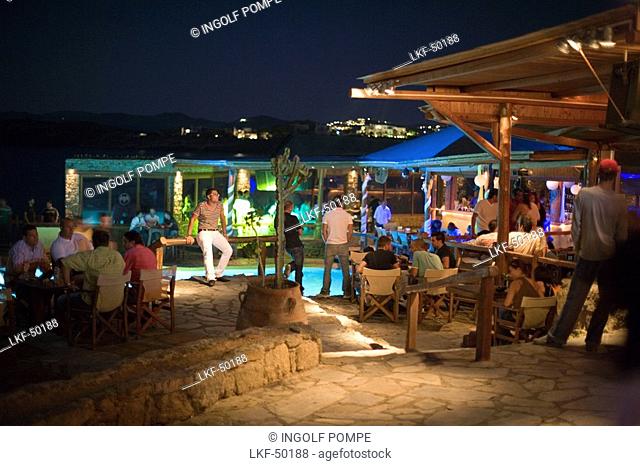 Tourists sitting in the open-air club of Cavo Paradiso, Paradise Beach, Mykonos, Greece