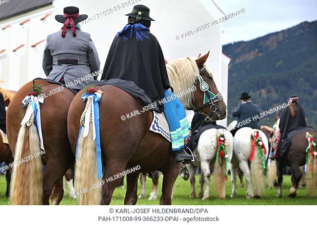 Men and women in traditional dress ride on festively adorned horses from the St. Coloman church near Schwangau, Germany, 8 October 2017