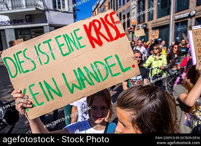 15 September 2023, Mecklenburg-Western Pomerania, Schwerin: A participant in a demonstration of the climate protection movement Fridays for Future carries a...