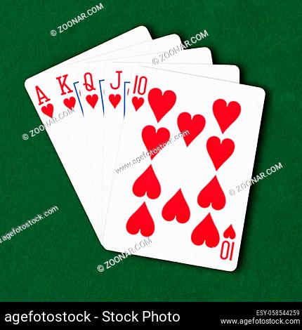 A royal flush in hearts on green card table winning hand business concept