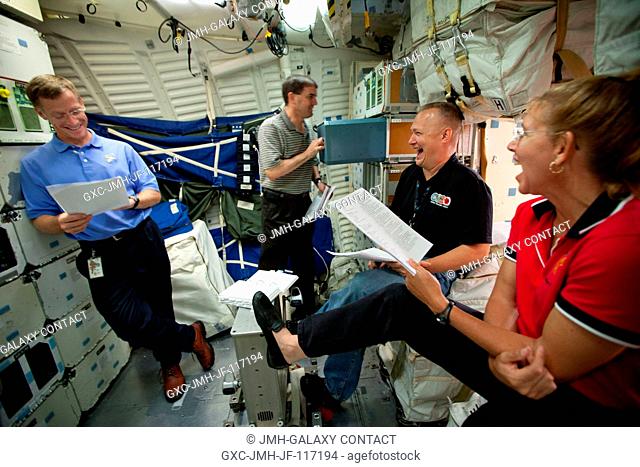 The crew of STS-135, from left, Chris Ferguson, Rex Walheim, Doug Hurley and Sandy Magnus, review procedures on the middeck of the Crew Compartment Trainer...