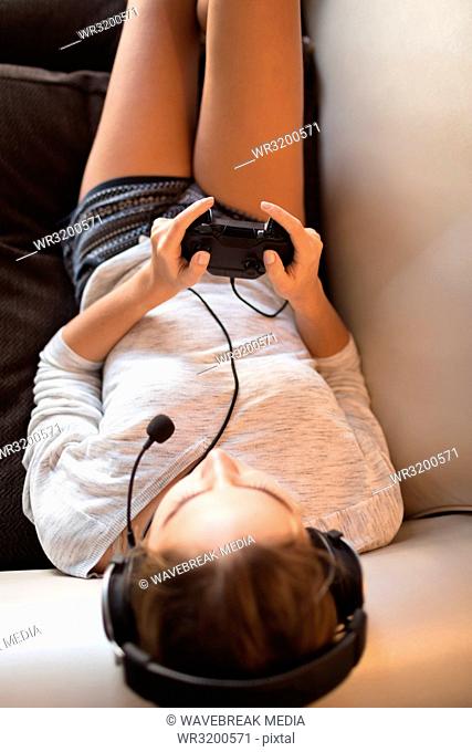 Woman playing video game with headset in living room