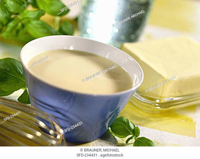 Butter sauce in bowl, butter, fresh basil