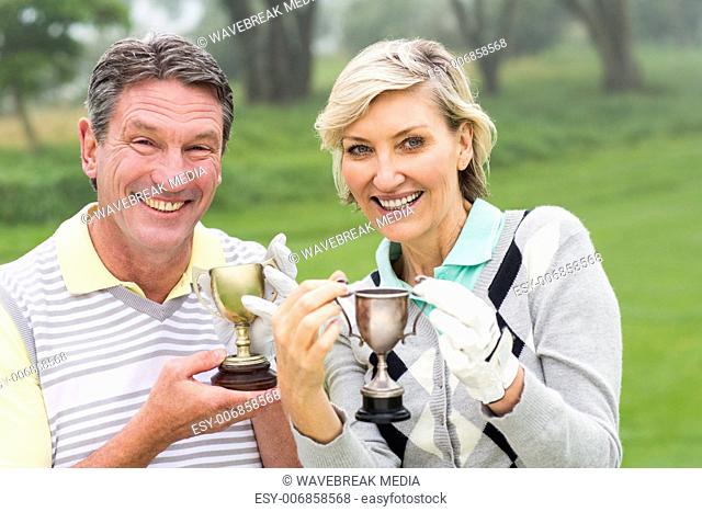 Happy golfing couple with trophy