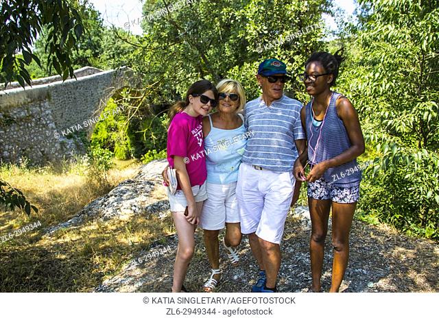 Grandparents on a family vacation in the south of france with grandchildren. Caucasian grandparents taking photos with their teenager granddaughters: One...
