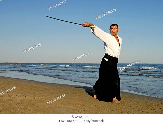 a young man are training in Aikido on the beach