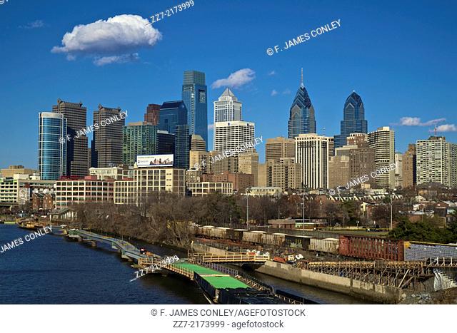 A freight train passes between the Philadelphia skyline and Schuylkill river