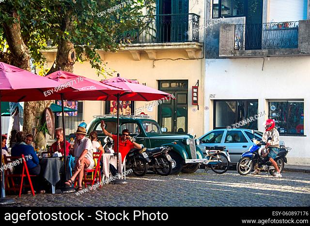 Colonia del Sacramento, Uruguay - April 5, 2013: Tourists enjoy a sunny autumn day in a street cafe in the historic center of one of the oldest towns in Uruguay