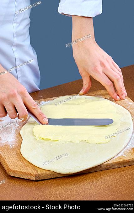 Chef smears butter on the dough for the preparation of baking cooking series full cooking food recipes