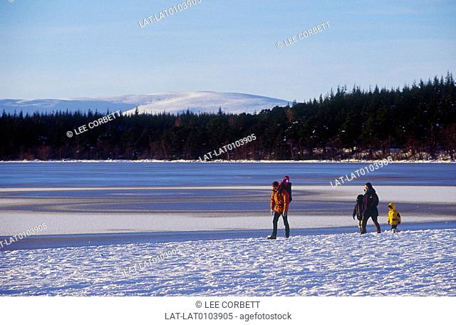 Glenmore. Snow on mountains. Lake, water. Snow on shore. Three people, family in coats