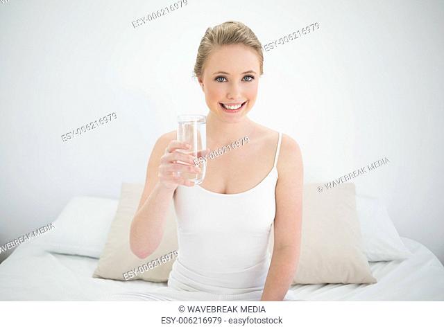 Natural smiling blonde holding glass of water