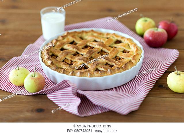 apple pie in baking mold on wooden table