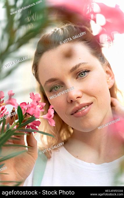 Portrait of young wiman with pink oleander flowers