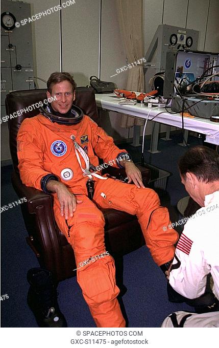 07/01/1997 --- STS-94 Mission Specialist Michael L. Gernhardt is assisted into his launch/entry suit by a suit technician in the Operations and Checkout O&C...