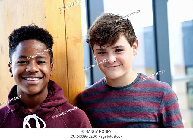 Portrait of two teenage schoolboys in corridor