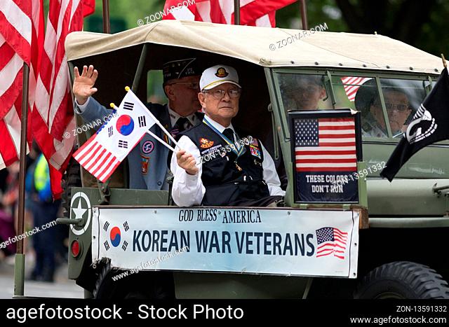 Washington, D.C., USA - May 28, 2018: The National Memorial Day Parade, Korean War Veteran going down constitution avenue waving American and South Korean Flags