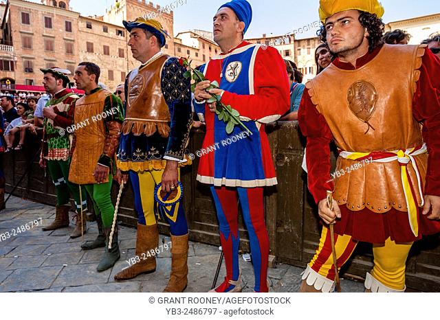 Representatives In Medieval Costume From Each Contrada Await The Tratta (The allocation of the horses) Ceremony, The Palio, Siena, Tuscany, Italy