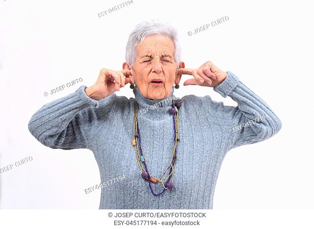 senior woman making noise hurting her ears on white background