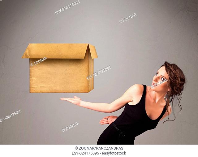 Young woman holding an empty cardboard box