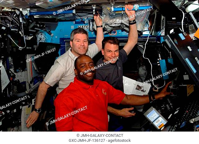 Astronauts Steve Frick (top left), STS-122 commander; Leland Melvin (bottom) and Stanley Love, both mission specialists, take a moment for a photo while working...