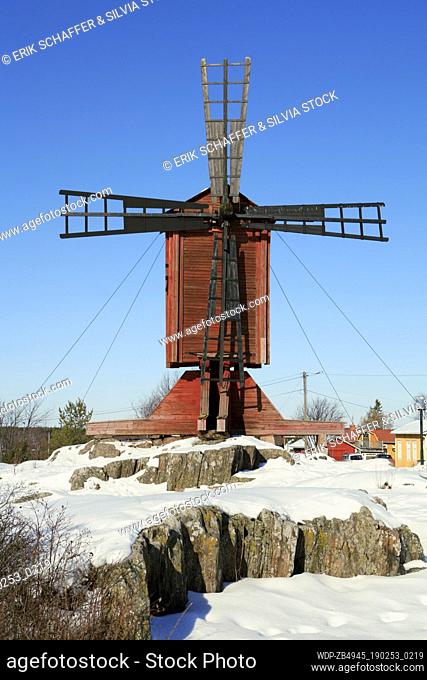 Old wooden windmill with blue sky and snow