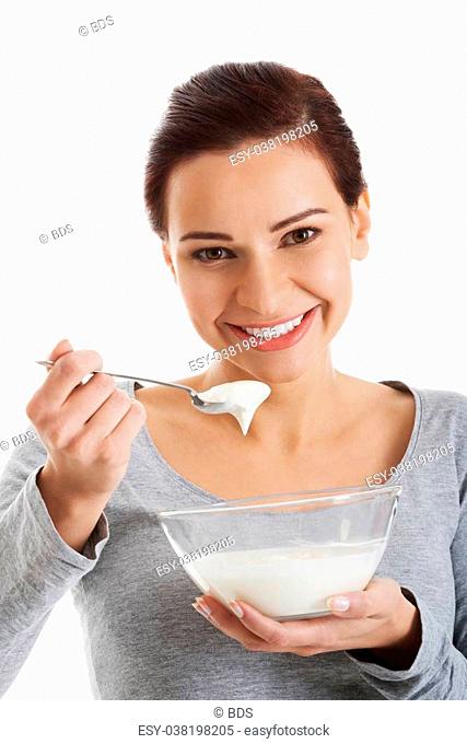 Young casual woman eating a yoghurt. Isolated on white