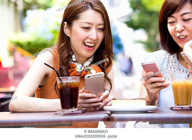 Business women operating their smart phone at an outdoor cafe