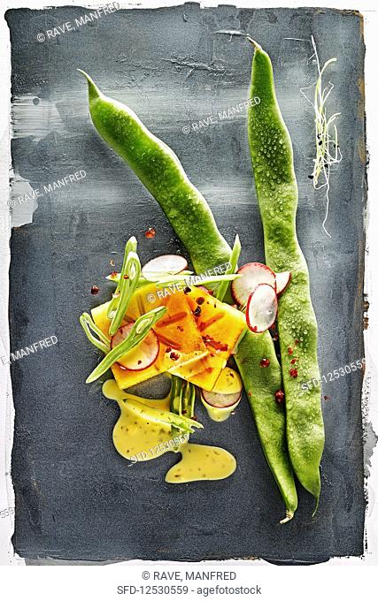Food art: green beans with persimmon, radishes and mustard sauce