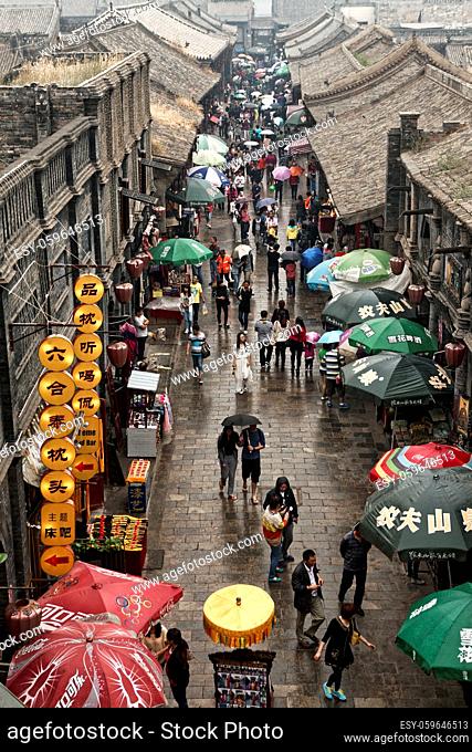 PINGYAO, CHINA - September 20, 2013 : Unidentified chinese people and tourists walk and shop on the ancient streets of Pingyao, China
