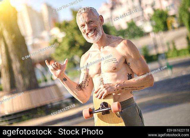 Active morning. A half-naked skateboarder holding a skateboard