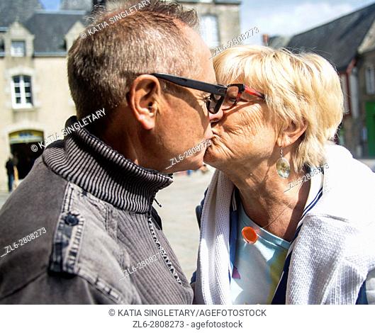 Older caucasian couple retired in love kissing each others, laughing and having a good times traveling together in summer. horizontal photo