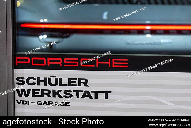 17 November 2022, Saxony, Leipzig: The taillights of a Porsche are reflected in the window of the Porsche student workshop at the VDI garage in Leipzig