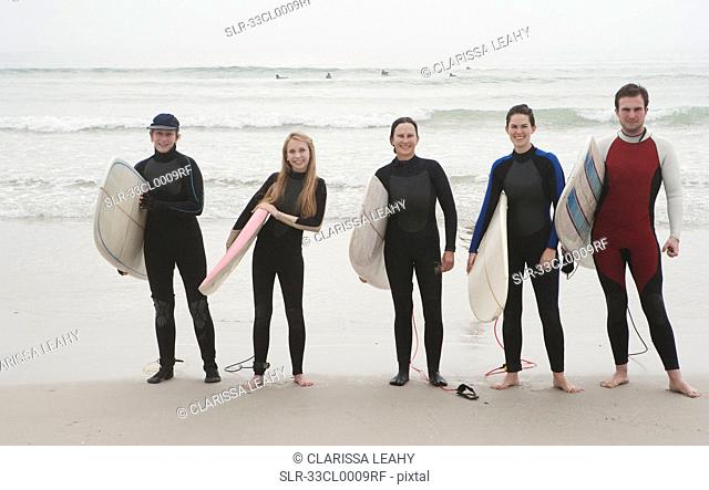 Family of surfers standing on beach